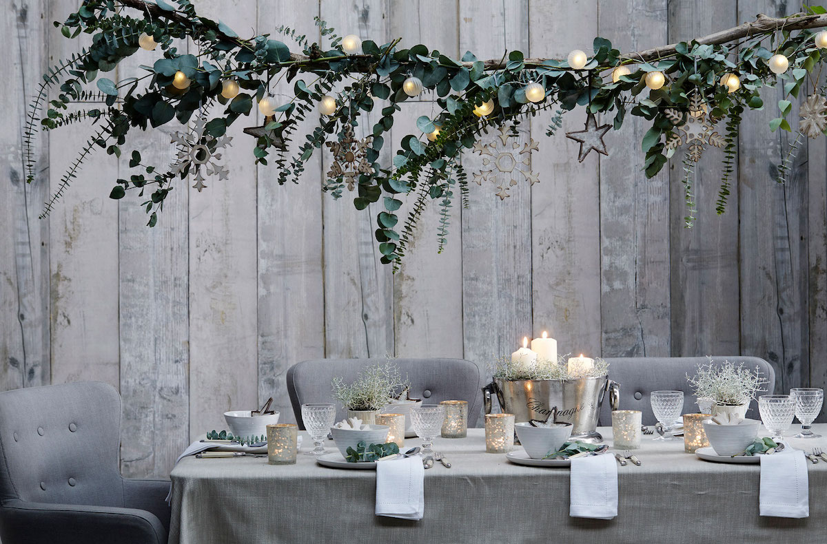 A dining table, which has been designed with branch chandelier above