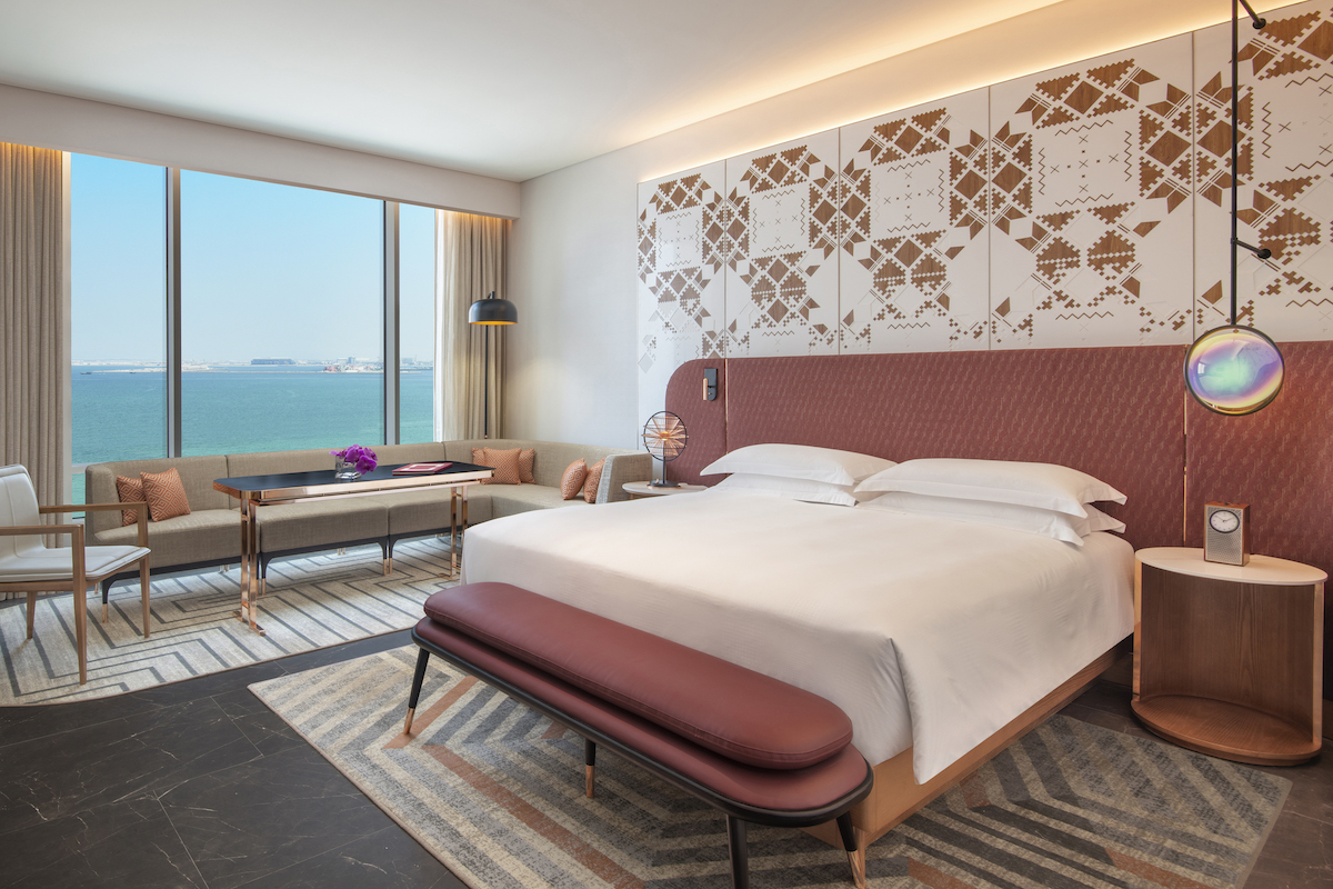 King room, with sea view with red-like headboard inside Andaz Doha