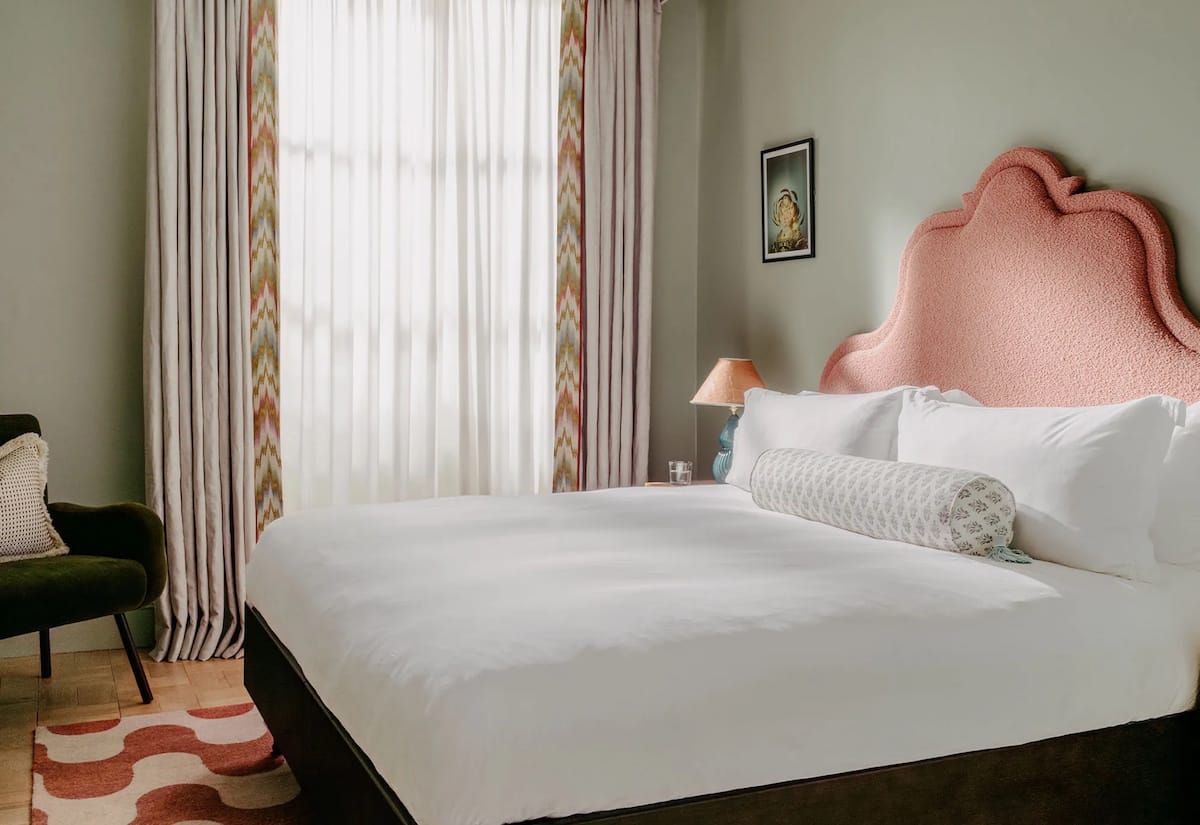 Modern guestroom with pink headboard and calming interiors