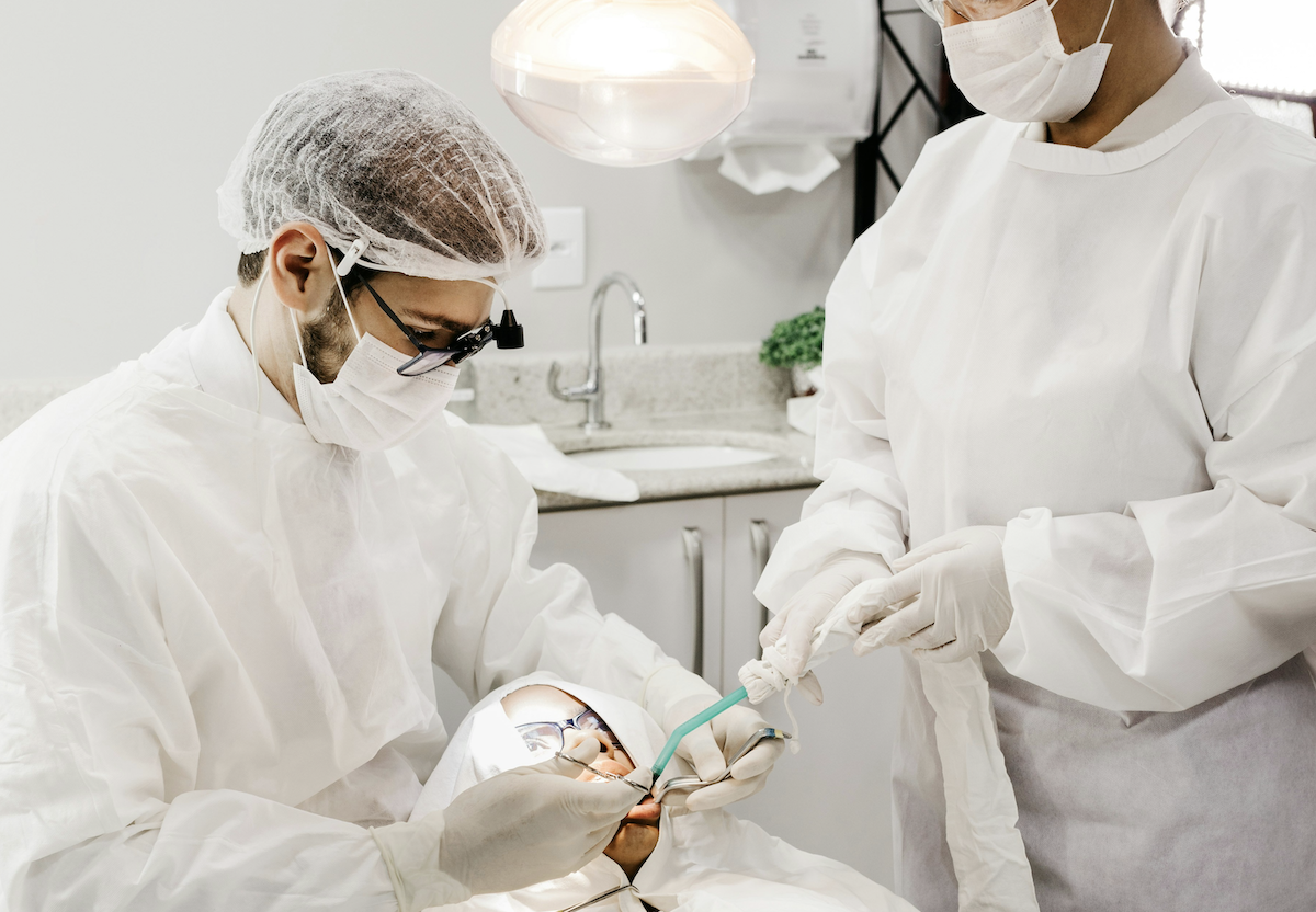 Dentist providing treatment with assistance of dental nurse