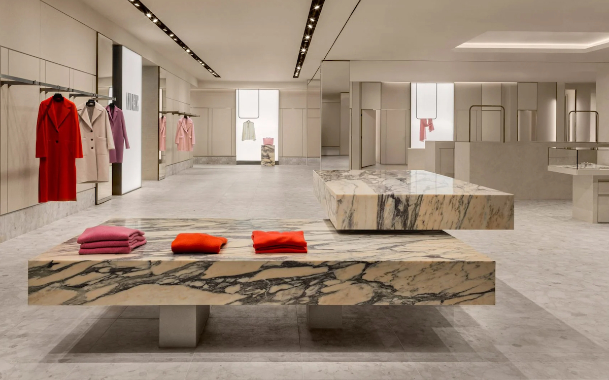 Andrews' sleek and contemporary showroom with minimalist design details and red clothing on hangers and folded on marble slabs