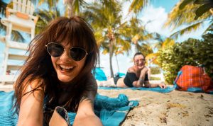 two women smiling on the beach in the summer