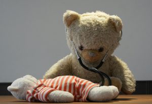 victorian stuffed bear with stethoscope against a sick stuffed bear